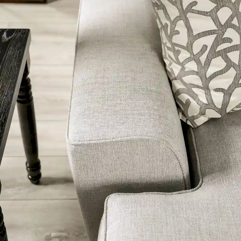 Transitional-style light gray fabric sofa, featuring nailhead trim and throw pillows