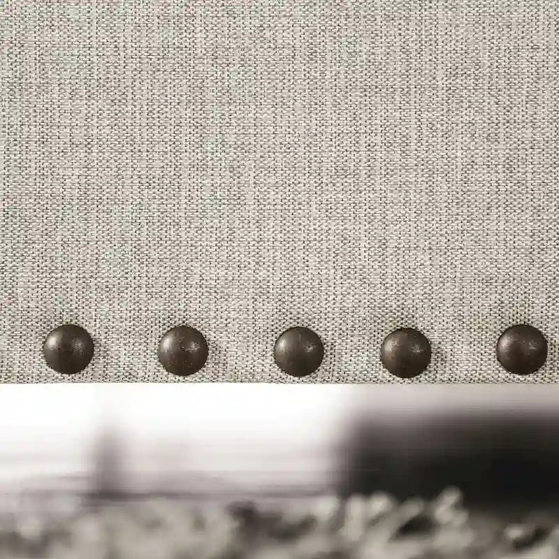 Transitional-style light gray fabric sofa, featuring nailhead trim and throw pillows