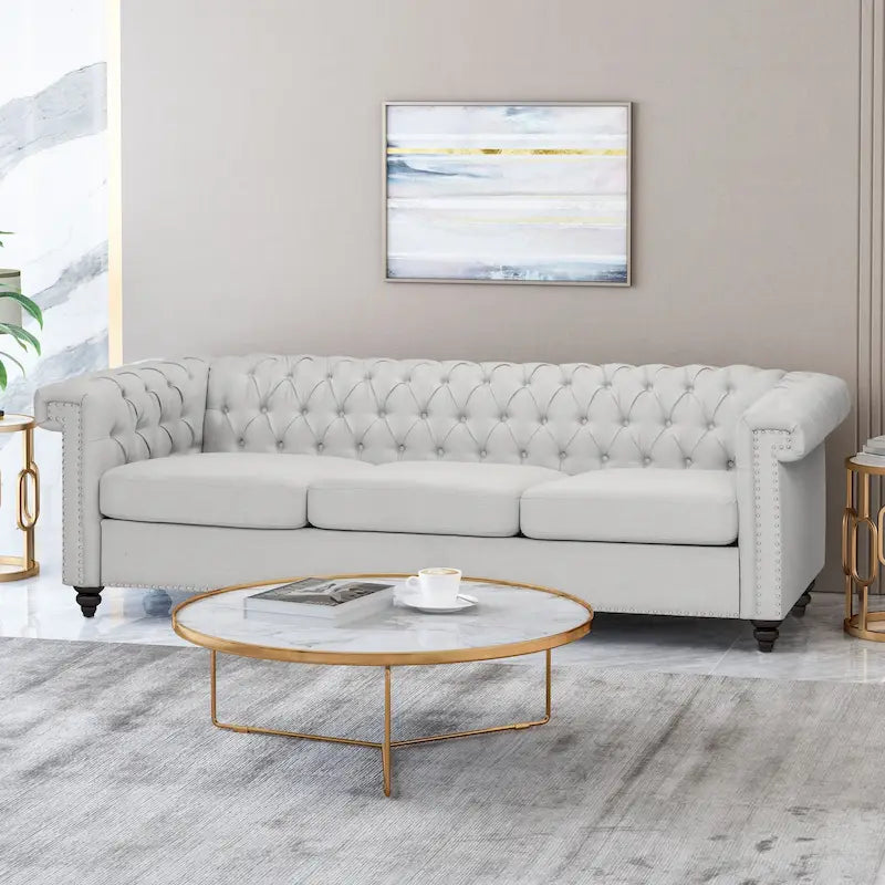 Szara sofa Chesterfield z pikowaniem w guziki